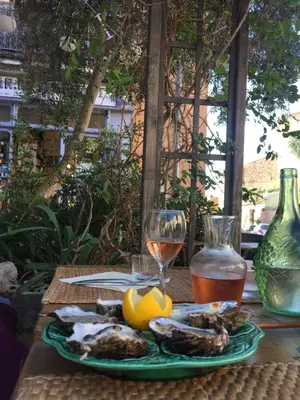 a table with a plate of food and a glass of wine at Appartement moderne, vue imprenable in Bages