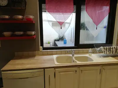 a kitchen with a sink and a window with curtains at CASA BLANCA à SIGEAN-GÎTE in Sigean