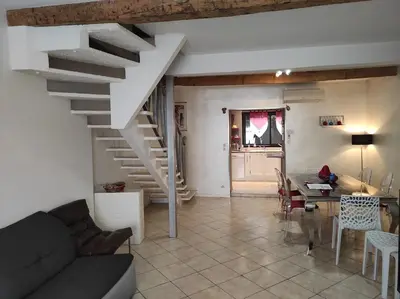 a living room with a staircase and a dining room at CASA BLANCA à SIGEAN-GÎTE in Sigean