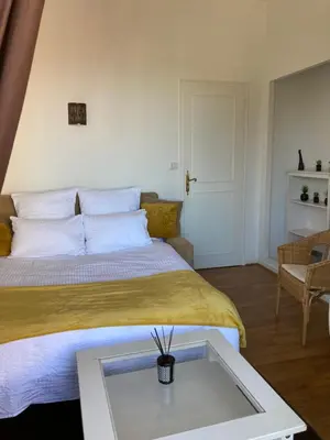 a bedroom with a bed with a glass table at Appart Aux deux Colombes avec Balcon et Garage in Pamiers