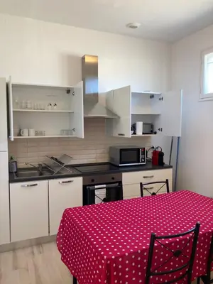 a kitchen with a table with a red polka dot table cloth at Appart Aux deux Colombes avec Balcon et Garage in Pamiers