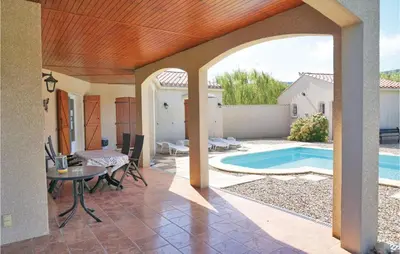 a patio with a table and a swimming pool at Stunning Home In Prades Sur Vernazobre in Prades-sur-Vernazobre