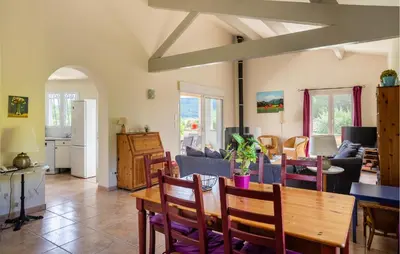 a dining room and living room with a table and chairs at Amazing Home In Prades Sur Vernazobre in Prades-sur-Vernazobre