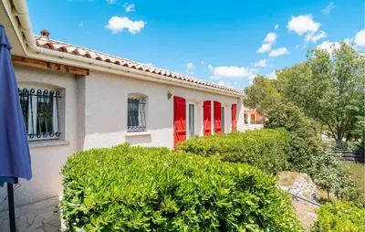 a white house with red doors and bushes at Amazing Home In Prades Sur Vernazobre in Prades-sur-Vernazobre