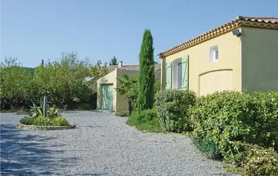 a house with a gravel driveway next to a building at Amazing Home In Cruzy in Cruzy