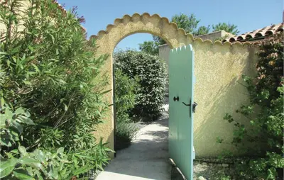 an entrance to a garden with a green door at Amazing Home In Cruzy in Cruzy