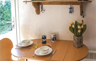 a table with plates and glasses and a vase of flowers at Amazing Home In Cruzy in Cruzy