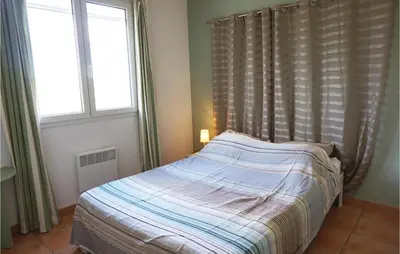 a bed in a bedroom with two windows at Amazing Home In Cruzy in Cruzy