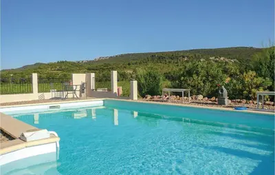 a large blue swimming pool with a mountain in the background at Beautiful Home In Prades Sur Vernazobre in Prades-sur-Vernazobre