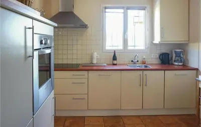 a kitchen with white cabinets and a sink and a window at Beautiful Home In Prades Sur Vernazobre in Prades-sur-Vernazobre