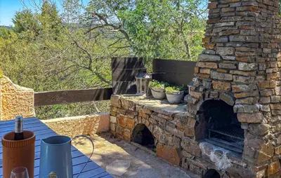 an outdoor brick oven with two potted plants on it at Awesome Home In Prades Sur Vernazobre in Prades-sur-Vernazobre