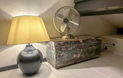 a fan sitting on a table next to a lamp at Awesome Home In Prades Sur Vernazobre in Prades-sur-Vernazobre