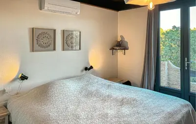 a bedroom with a bed and a large window at Awesome Home In Prades Sur Vernazobre in Prades-sur-Vernazobre