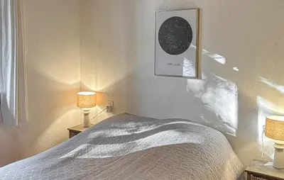 a bedroom with a bed with two lamps and a picture at Awesome Home In Prades Sur Vernazobre in Prades-sur-Vernazobre
