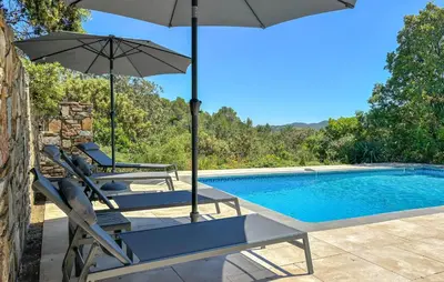 a swimming pool with two chairs and an umbrella at Awesome Home In Prades Sur Vernazobre in Prades-sur-Vernazobre