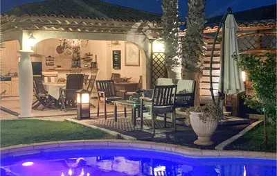 a patio with a table and chairs next to a pool at Cozy Home In Puisserguier in Puisserguier