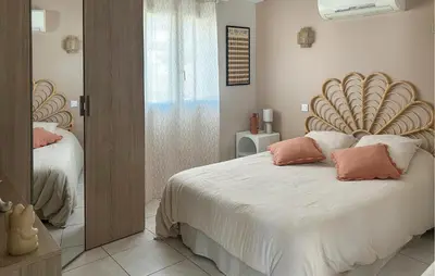 a bedroom with a large bed with a wooden headboard at Cozy Home In Puisserguier in Puisserguier