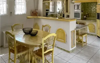 a kitchen with a wooden table and chairs in a kitchen at Cozy Home In Puisserguier in Puisserguier
