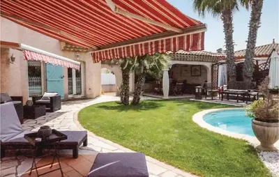 a patio with a yard with a pool and a house at Cozy Home In Puisserguier in Puisserguier