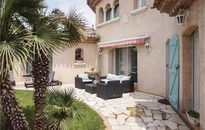a house with a palm tree and a patio at Cozy Home In Puisserguier in Puisserguier