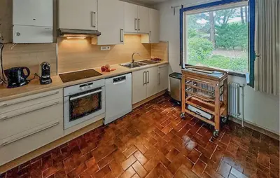 a kitchen with white cabinets and a large window at Nice Home In Cesseras With Wifi in Cesseras