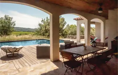 a patio with a table and chairs and a pool at Beautiful Home In Prades-Sur-Vernazobre in Prades-sur-Vernazobre