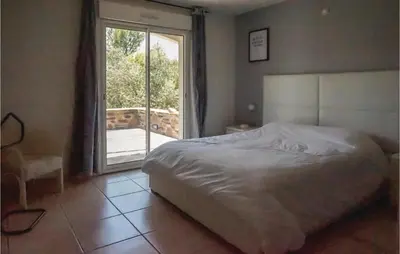 a bedroom with a bed and a sliding glass door at Beautiful Home In Prades-Sur-Vernazobre in Prades-sur-Vernazobre