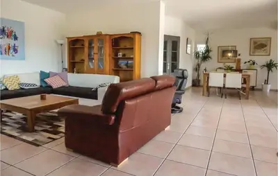 a living room with a leather couch and a table at Beautiful Home In Prades-Sur-Vernazobre in Prades-sur-Vernazobre