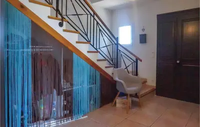 a room with a staircase with a chair and a door at Beautiful Home In Prades-Sur-Vernazobre in Prades-sur-Vernazobre