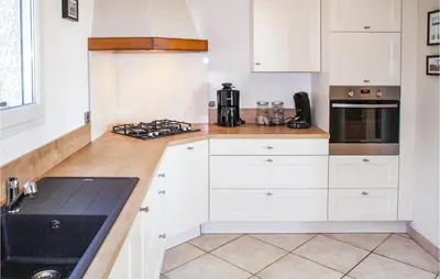 a kitchen with white cabinets and a black sink at Nice Home In Caunes Minervois With Wifi in Caunes-Minervois