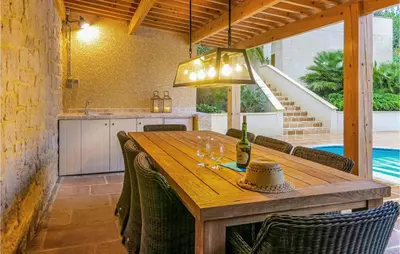 a dining room with a wooden table with wine glasses at Nice Home In Caunes Minervois With Wifi in Caunes-Minervois