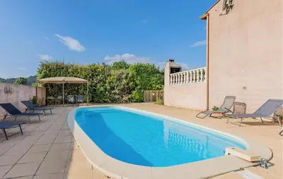 a swimming pool on a patio with chairs and an umbrella at Gorgeous Home In Cessenon Sur Orb in Cessenon