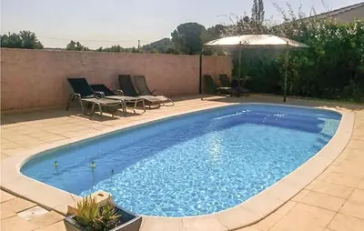 a large blue swimming pool with chairs and an umbrella at Gorgeous Home In Cessenon Sur Orb in Cessenon