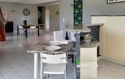 a kitchen with white chairs and a counter top at 3 Bedroom Cozy Home In Quarante in Quarante