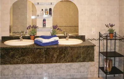 a bathroom with two sinks and a large mirror at 3 Bedroom Cozy Home In Quarante in Quarante