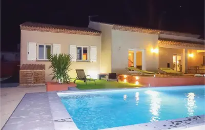 a villa with a swimming pool at night at 3 Bedroom Cozy Home In Quarante in Quarante