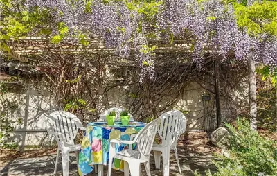 a table with chairs and a wreath of purple flowers at Amazing Home In Cruzy in Cruzy