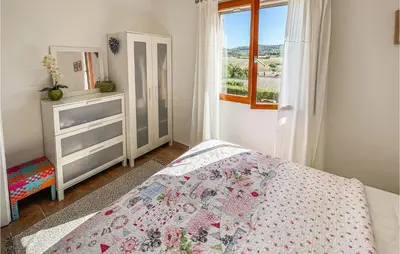a bedroom with a bed and a dresser and a window at Amazing Home In Cruzy in Cruzy