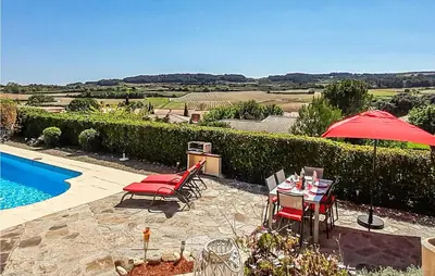 a patio with a table and chairs and an umbrella at Amazing Home In Cruzy in Cruzy