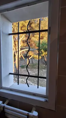 a window with a snake growing out of it at Le Studio des 3 Moulins in Sigean
