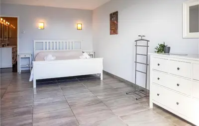 a bedroom with a white bed and a tiled floor at 3 Bedroom Cozy Home In Caunes Minervois in Caunes-Minervois