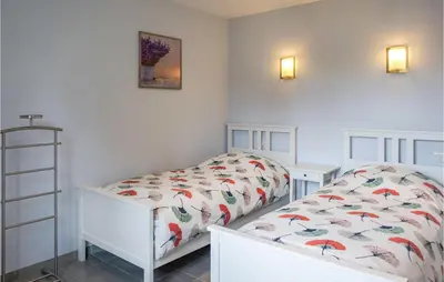 a bedroom with two twin beds and a crib at 3 Bedroom Cozy Home In Caunes Minervois in Caunes-Minervois