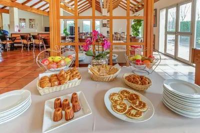 a table with baskets of bread and pastries on it at Brit Hotel Confort Castres in Castres