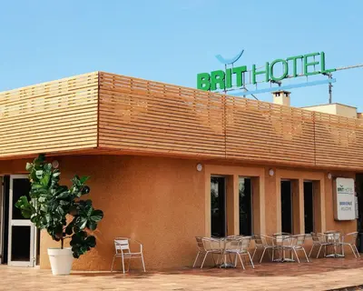 a building with chairs and a sign on top of it at Brit Hotel Confort Castres in Castres