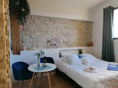 a bedroom with a bed and a table and a wall at Villa Sainte Marie in Narbonne