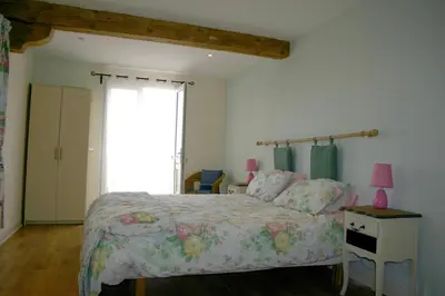 a bedroom with a bed and a large window at Domaine De Polfages in Villautou