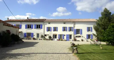 a large white house with blue shutters at Domaine De Polfages in Villautou