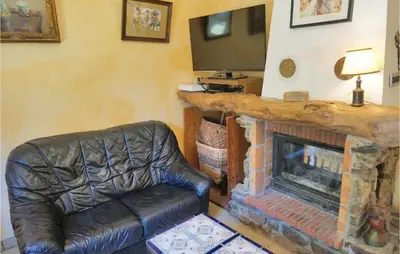 a living room with a leather chair and a fireplace at Amazing Home In Prades Sur Vernazobre in Prades-sur-Vernazobre
