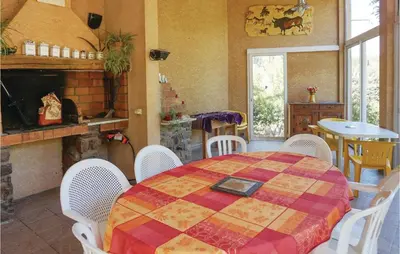 a dining room with a table and chairs and a fireplace at Amazing Home In Prades Sur Vernazobre in Prades-sur-Vernazobre
