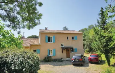 a house with two cars parked in front of it at Amazing Home In Prades Sur Vernazobre in Prades-sur-Vernazobre